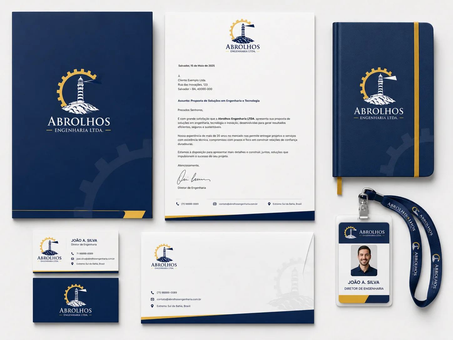 Papelaria institucional da Abrolhos Engenharia: pasta azul-marinho, papel timbrado com carta-proposta, caderno com elástico dourado, cartões de visita, envelope e crachá com cordão